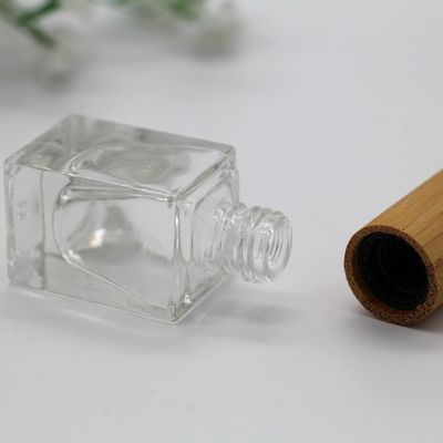 正方形のマニキュアのびんのタケ帽子は化粧品のガラス ビンに空のびんを構成する