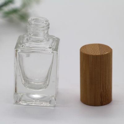 正方形のマニキュアのびんのタケ帽子は化粧品のガラス ビンに空のびんを構成する